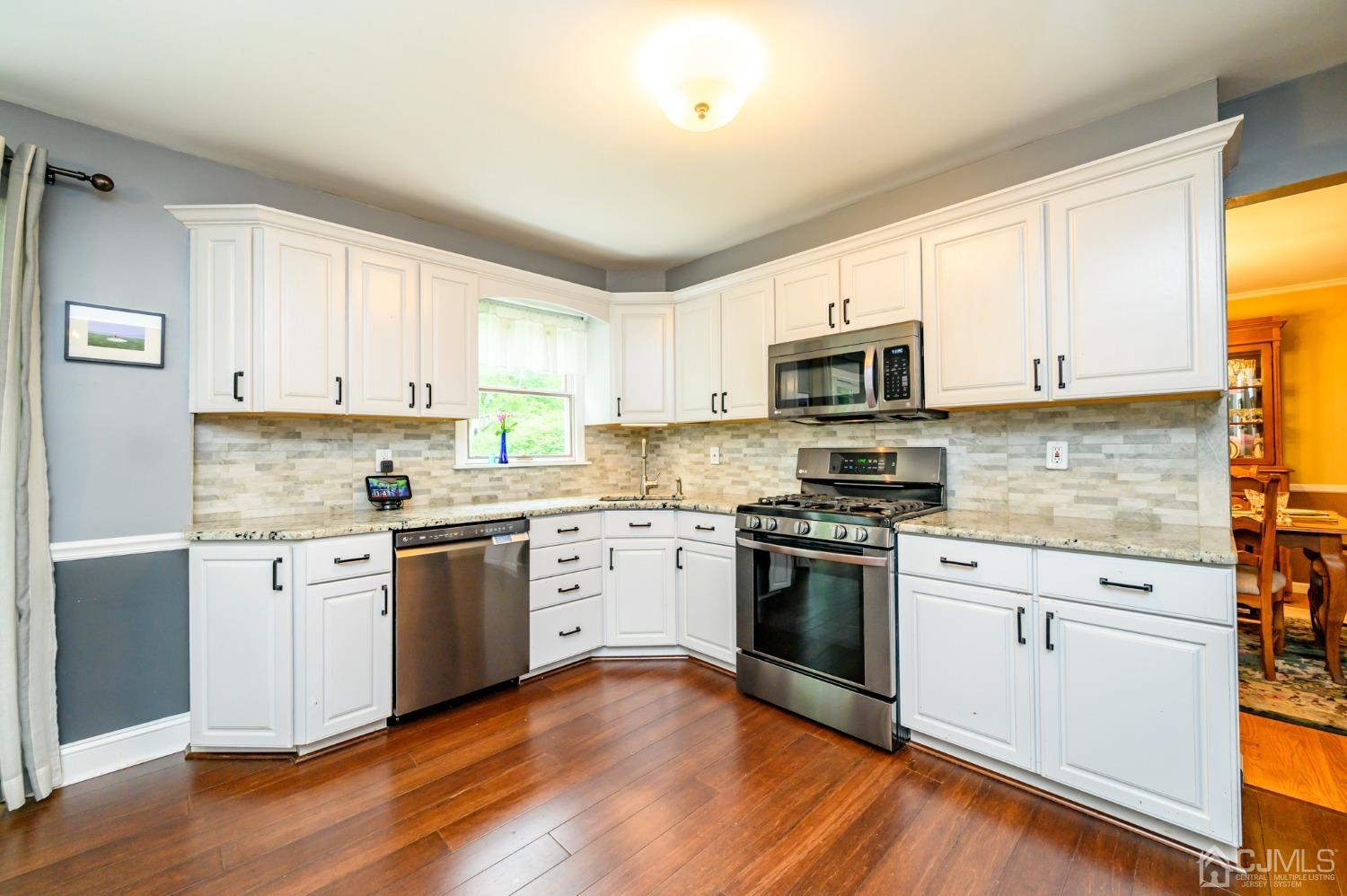 95 Glenside Road New Providence, NJ 07974 - Photo 11 of 46 a kitchen with granite countertop white cabinets and stainless steel appliances