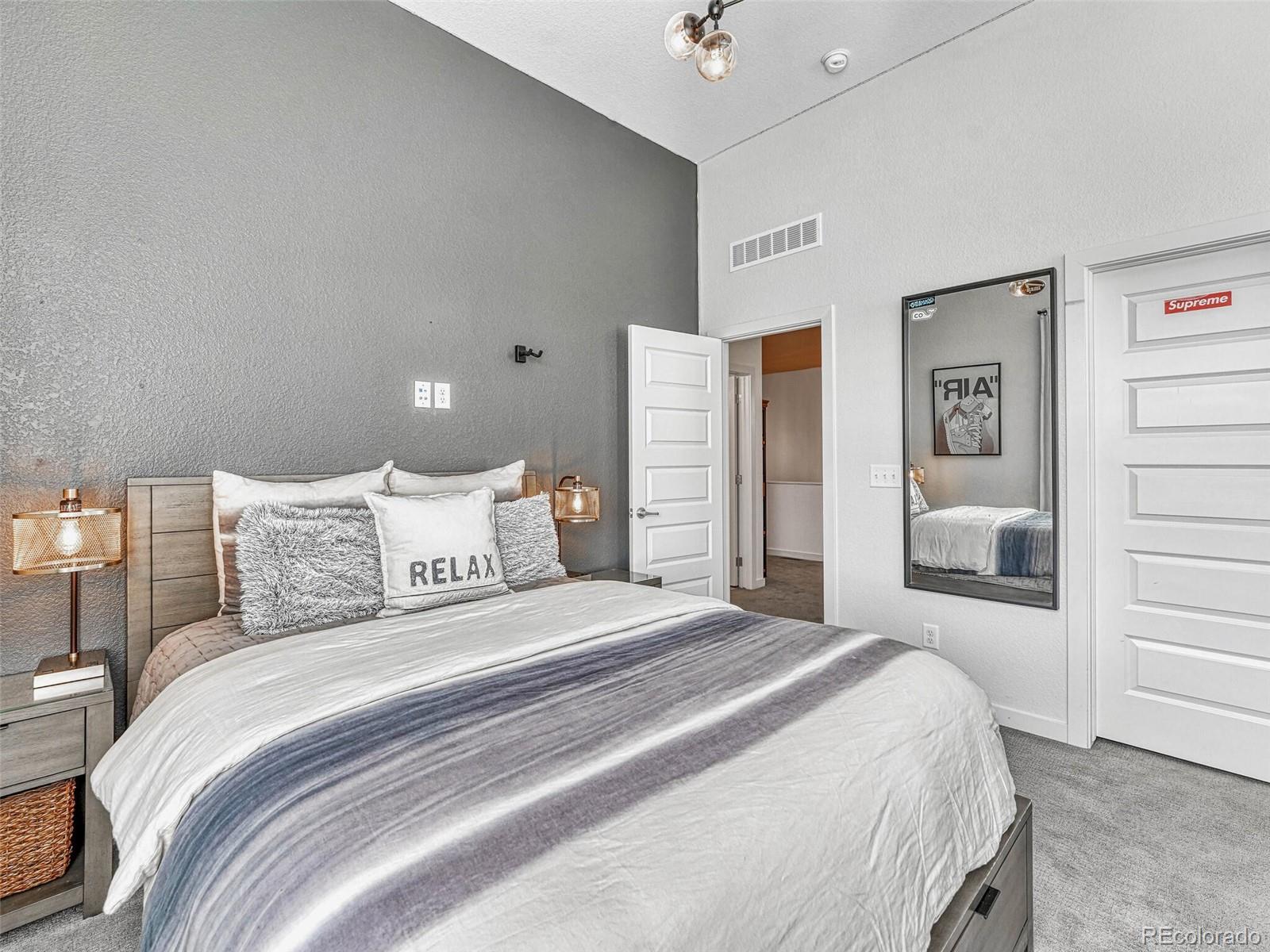 10132 Belvedere Loop Lone Tree, CO 80124 - Photo 19 of 37 a bedroom with a large bed and a chandelier