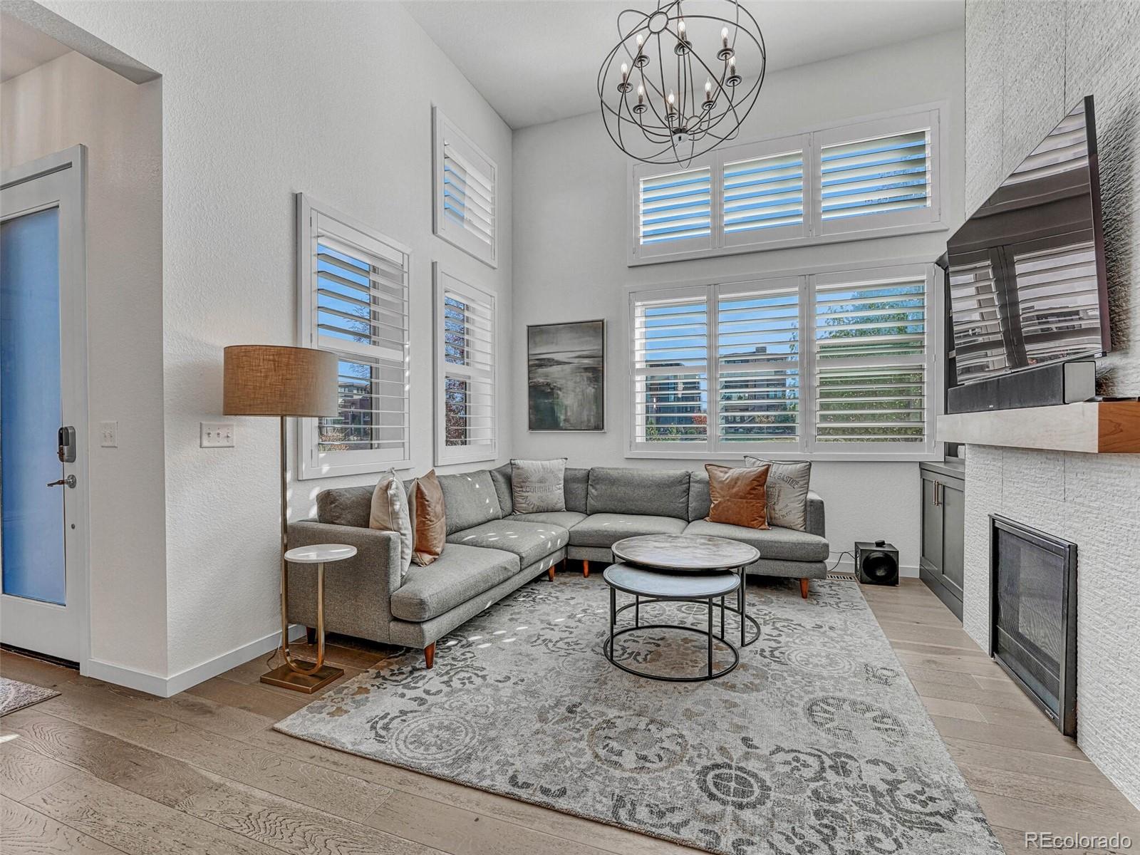 10132 Belvedere Loop Lone Tree, CO 80124 - Photo 4 of 37 a living room with furniture a fireplace and a large window