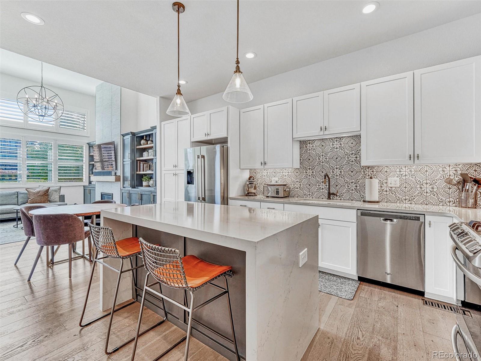 10132 Belvedere Loop Lone Tree, CO 80124 - Photo 10 of 37 a kitchen with stainless steel appliances granite countertop a kitchen island a stove a table and chairs in it