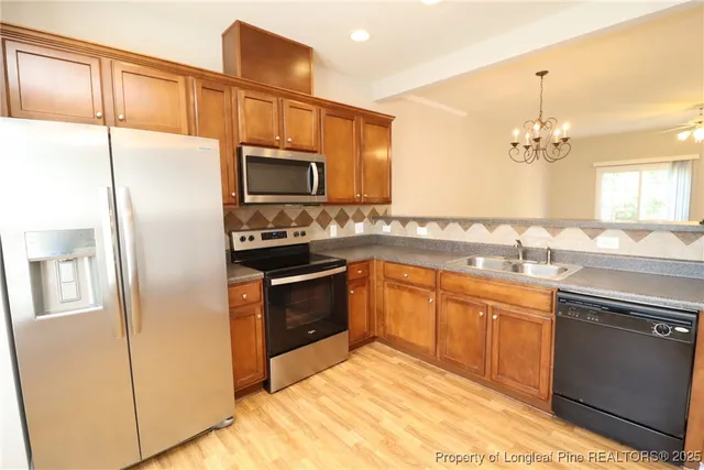 a kitchen with stainless steel appliances a refrigerator sink and microwave