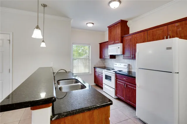 a kitchen with stainless steel appliances granite countertop a sink refrigerator and stove