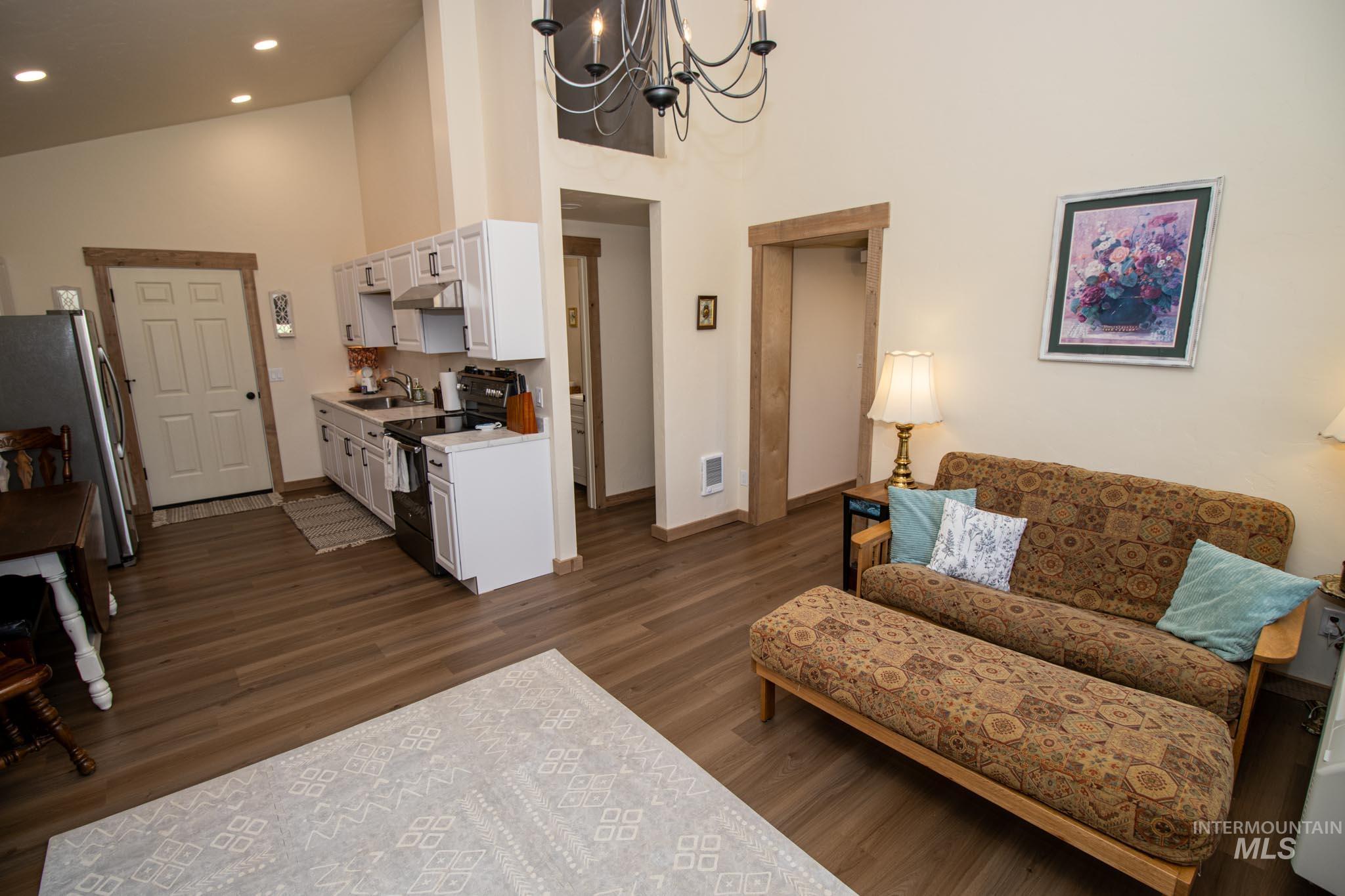 263 Glory Lane Orofino, ID 83544 - Photo 32 of 48 Living area featuring hanging lights, dark wood-style floors, and lofted ceiling