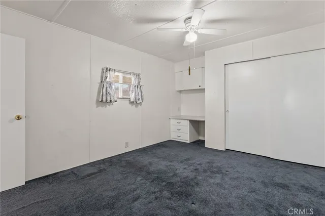 an empty room with a ceiling fan and a window