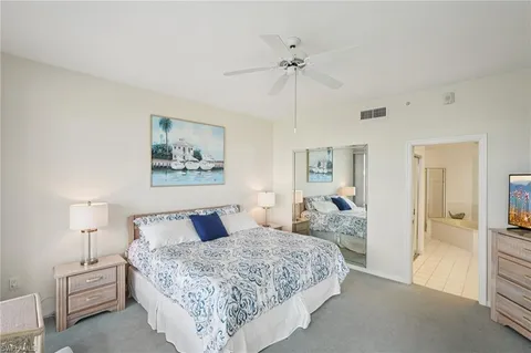 a bedroom with a large bed and a chandelier