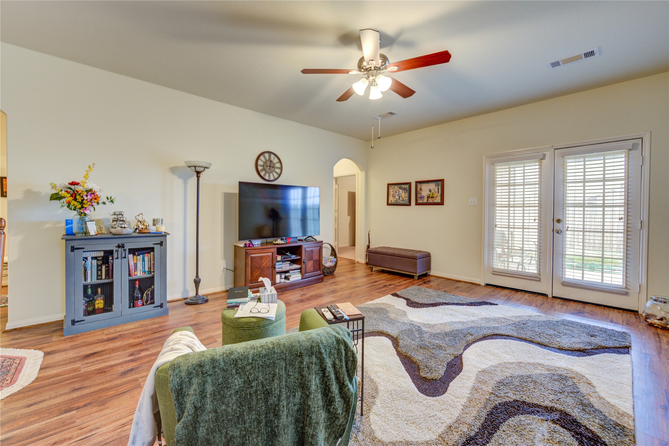 9443 Sky Blue Drive Rosharon, TX 77583 - Photo 11 of 23 Open-concept living area with warm laminate flooring, a ceiling fan, and neutral walls.