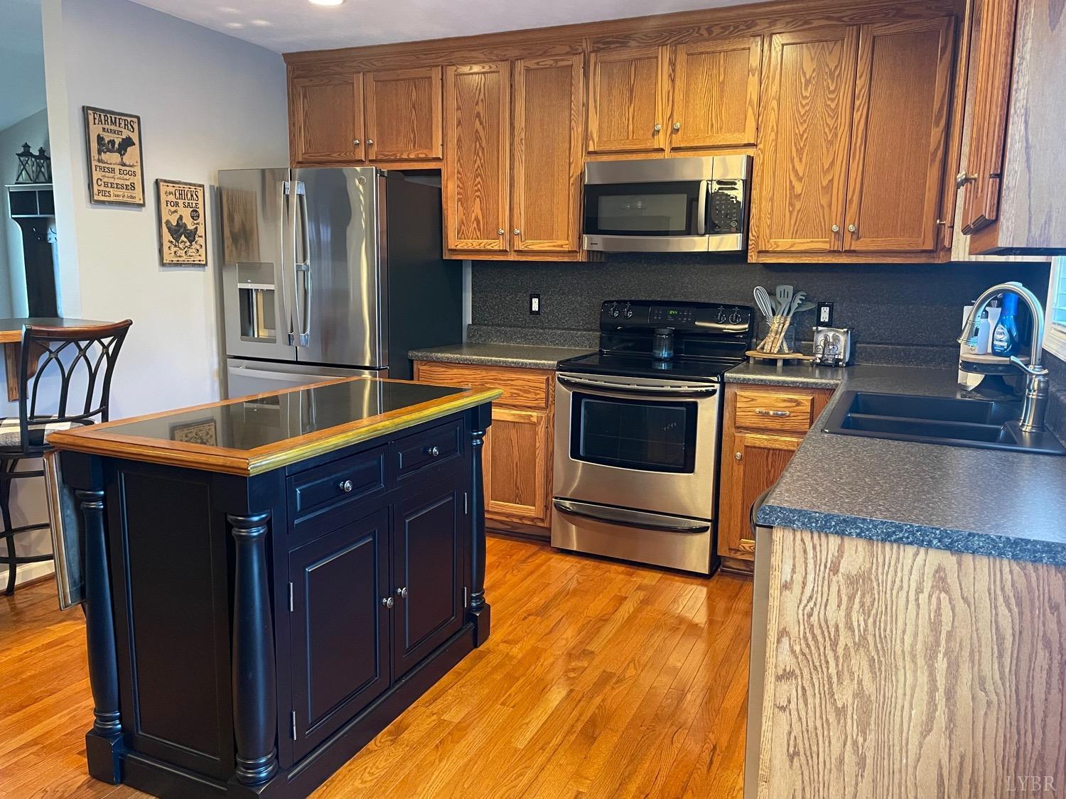 7207 Stage Road Concord, VA 24538 - Photo 12 of 29 a kitchen with granite countertop wooden cabinets and stainless steel appliances