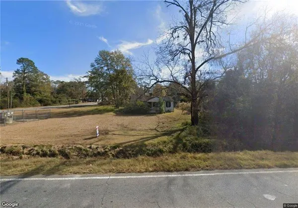 a view of a yard with wooden fence