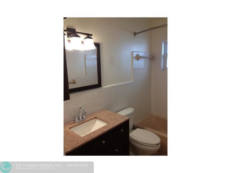 2404 Northeast 33rd Avenue, Unit 12 Fort Lauderdale, FL 33305 - Photo 9 of 13 a bathroom with a sink toilet and mirror