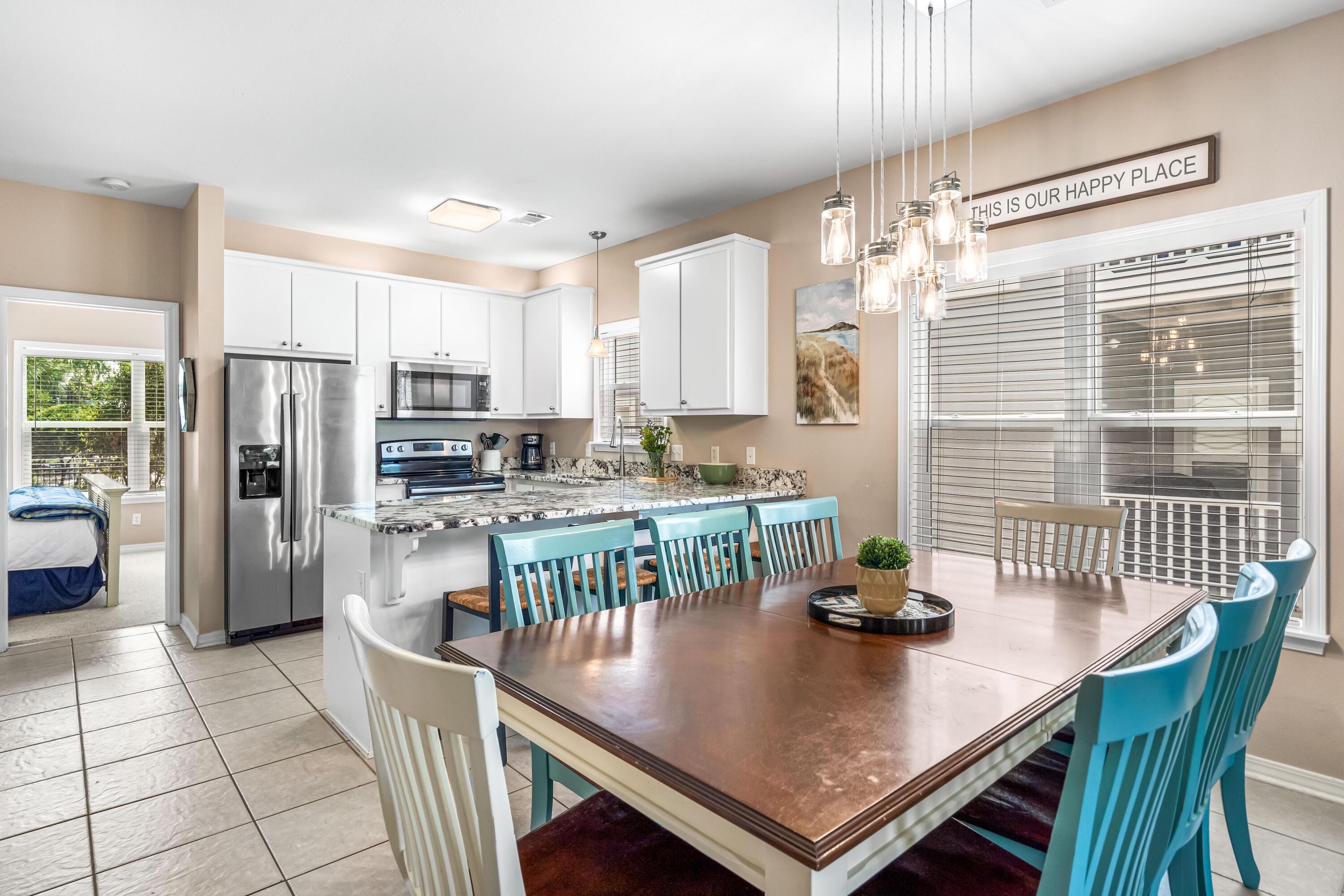 120 Hidden Lake Way Santa Rosa Beach, FL 32459 - Photo 8 of 56 a kitchen with stainless steel appliances a dining table chairs a refrigerator and cabinets