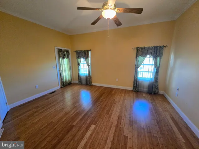 a view of an empty room with wooden floor