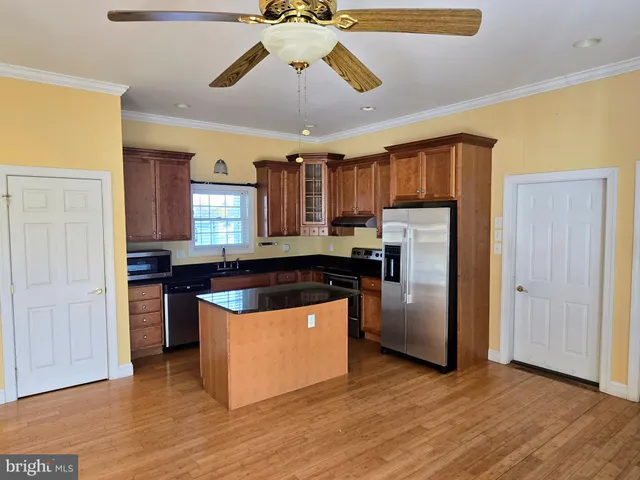 a view of a kitchen with cabinets stainless steel appliances a sink and a window