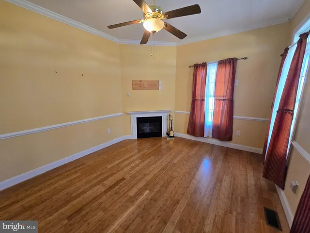 a view of empty room with wooden floor