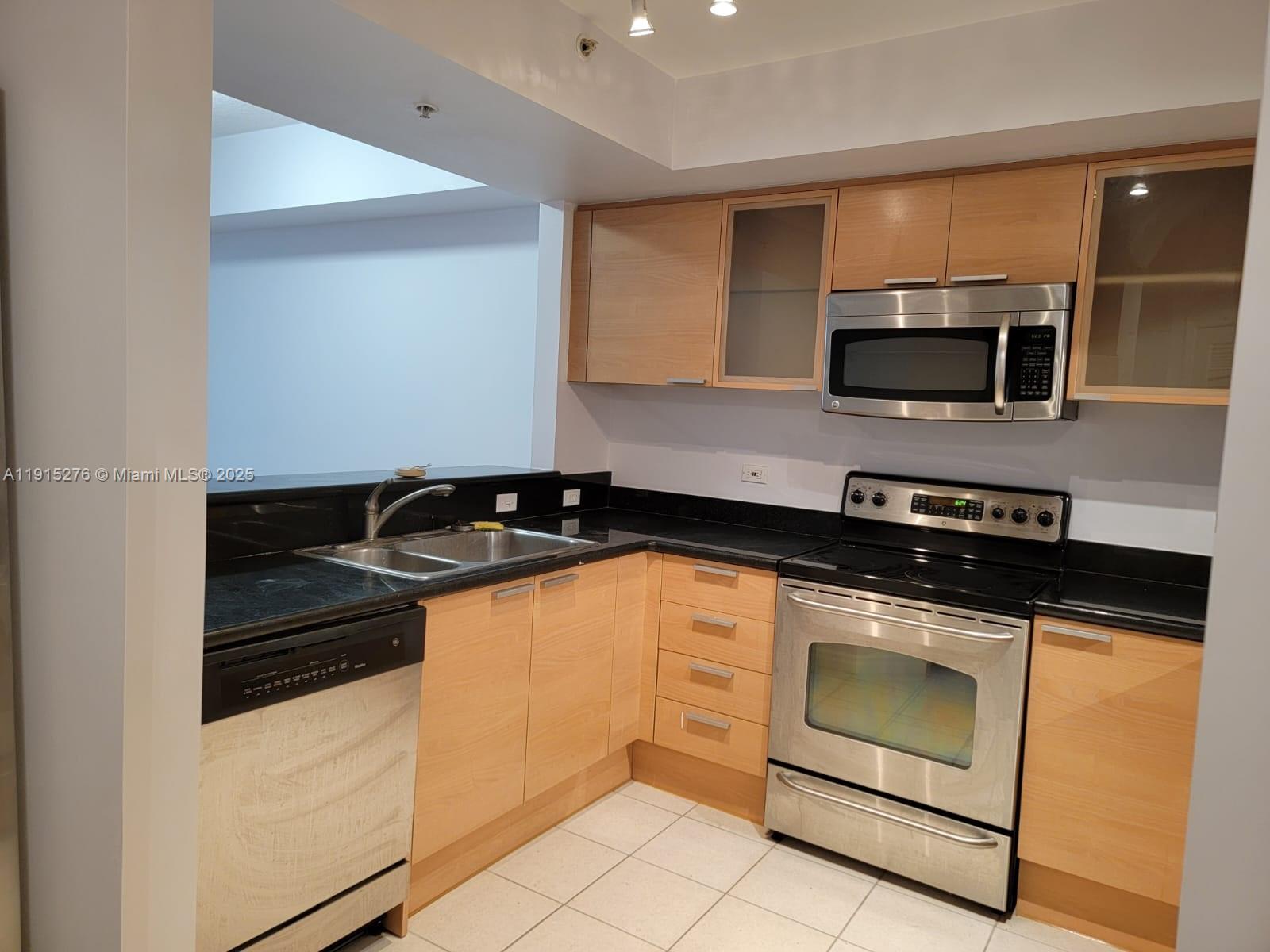 140 South Dixie Highway, Unit 908 Hollywood, FL 33020 - Photo 19 of 28 a kitchen with granite countertop a stove and a microwave