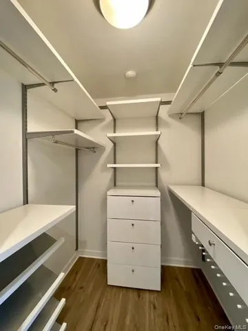 a room with a white bed and a dresser