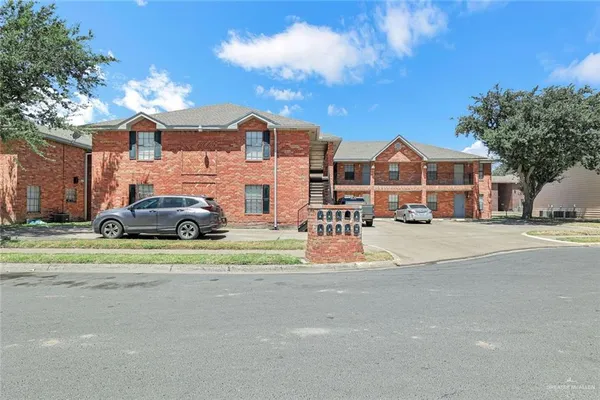 a front view of a house with a garden and parking
