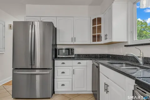 a kitchen with stainless steel appliances granite countertop a refrigerator sink and cabinets