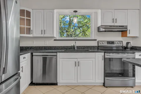 a kitchen with stainless steel appliances granite countertop a sink and a stove