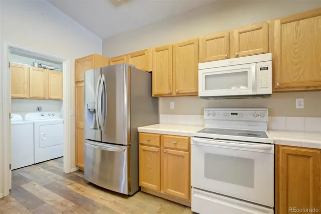 a kitchen with white cabinets and white appliances