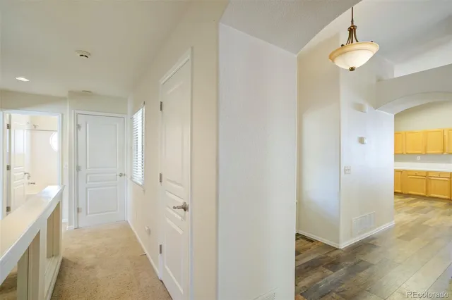 a view of a hallway with wooden floor and cabinet
