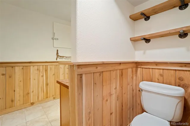a bathroom with a toilet a sink and wooden floor