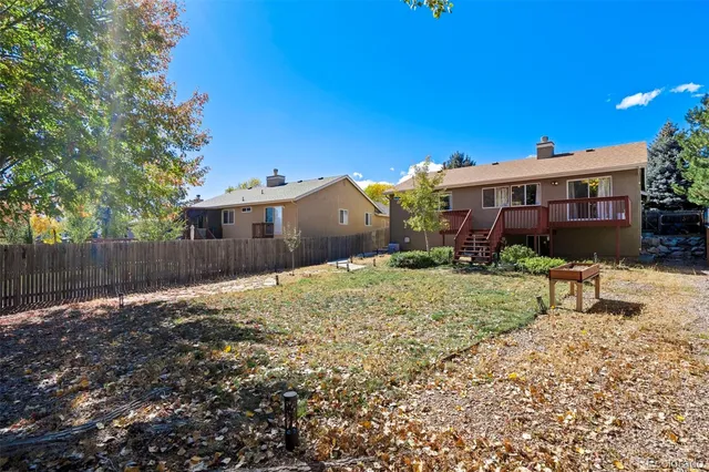 a backyard of a house with plants and tree