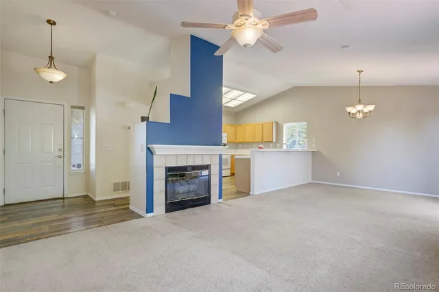 an empty room with fan and fireplace