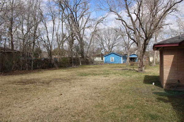 a view of yard with tree in front of it