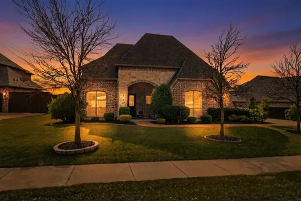 a front view of a house with garden and trees