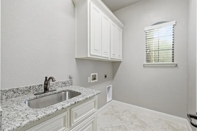 a kitchen with granite countertop a sink and a white cabinets
