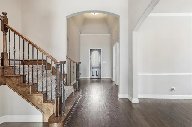 a view of a hallway with wooden floor and staircase