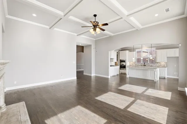 a view of a living room with wooden floor and a ceiling fan