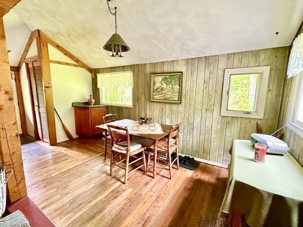 100 Aberdeen Road Goshen, MA 01096 - Photo 17 of 27 a dining room with wooden floor a chandelier a wooden table and chairs