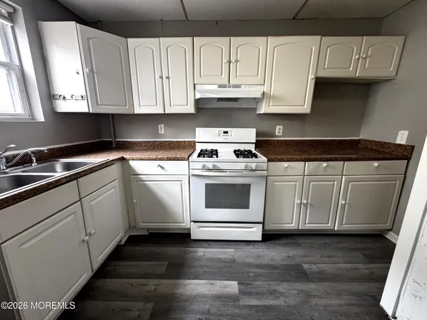 a kitchen with granite countertop white cabinets and white appliances