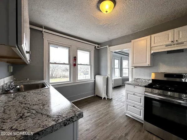a kitchen with granite countertop a stove a sink and a granite counter tops
