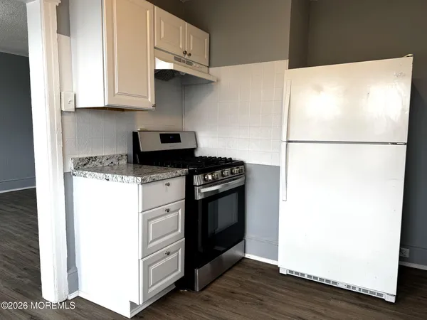 a white refrigerator freezer and a wooden floor