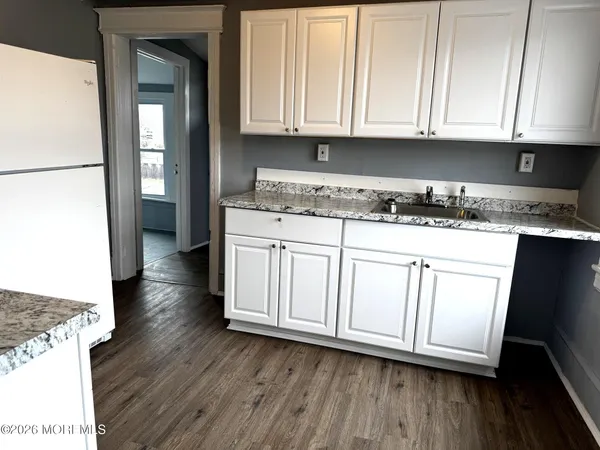 a kitchen with granite countertop a sink a stove and cabinets