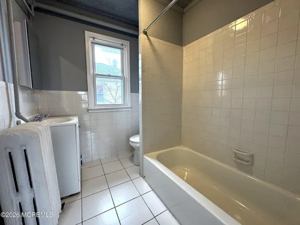 a bathroom with a granite countertop bathtub a toilet and a sink