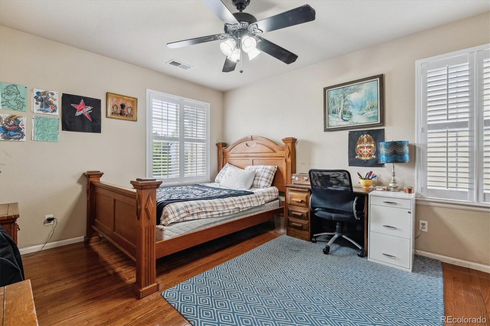 2891 Canyon Crest Drive Highlands Ranch, CO 80126 - Photo 30 of 41 a bedroom with a bed and a chandelier