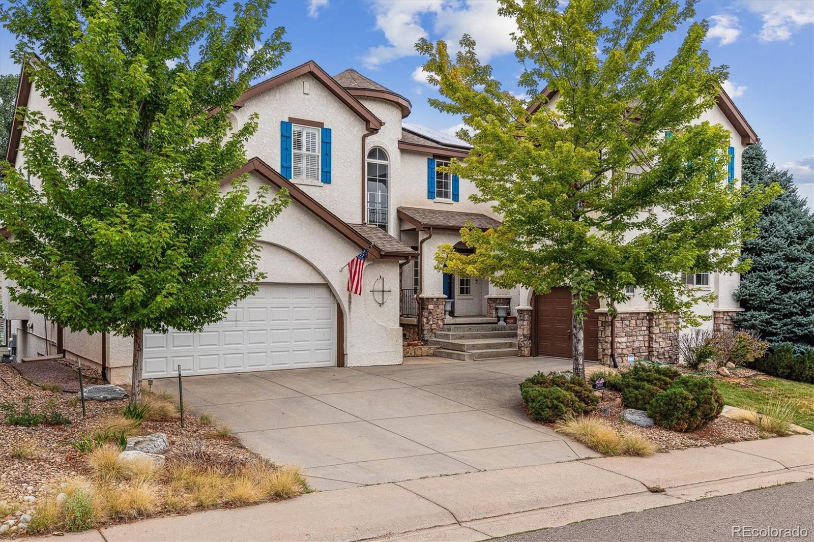 2891 Canyon Crest Drive Highlands Ranch, CO 80126 - Photo 41 of 41 a front view of a house with a yard and potted plants