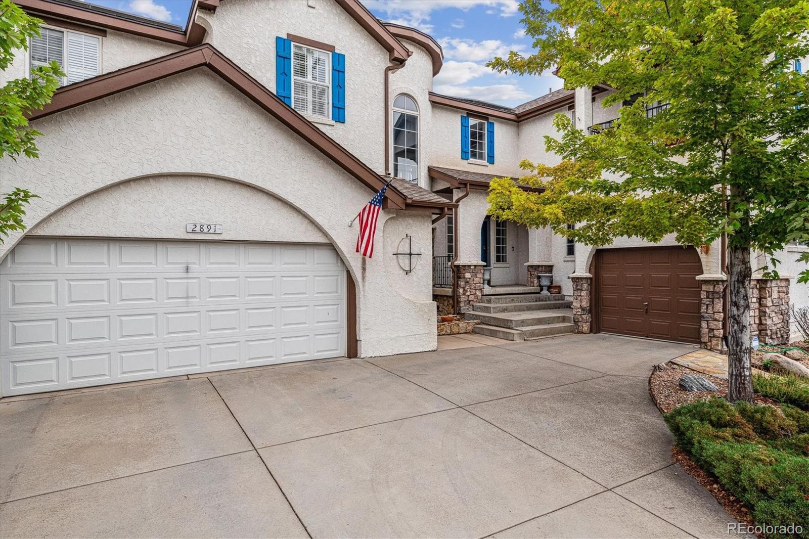 2891 Canyon Crest Drive Highlands Ranch, CO 80126 - Photo 6 of 41 a view of a white house with large windows and a small yard