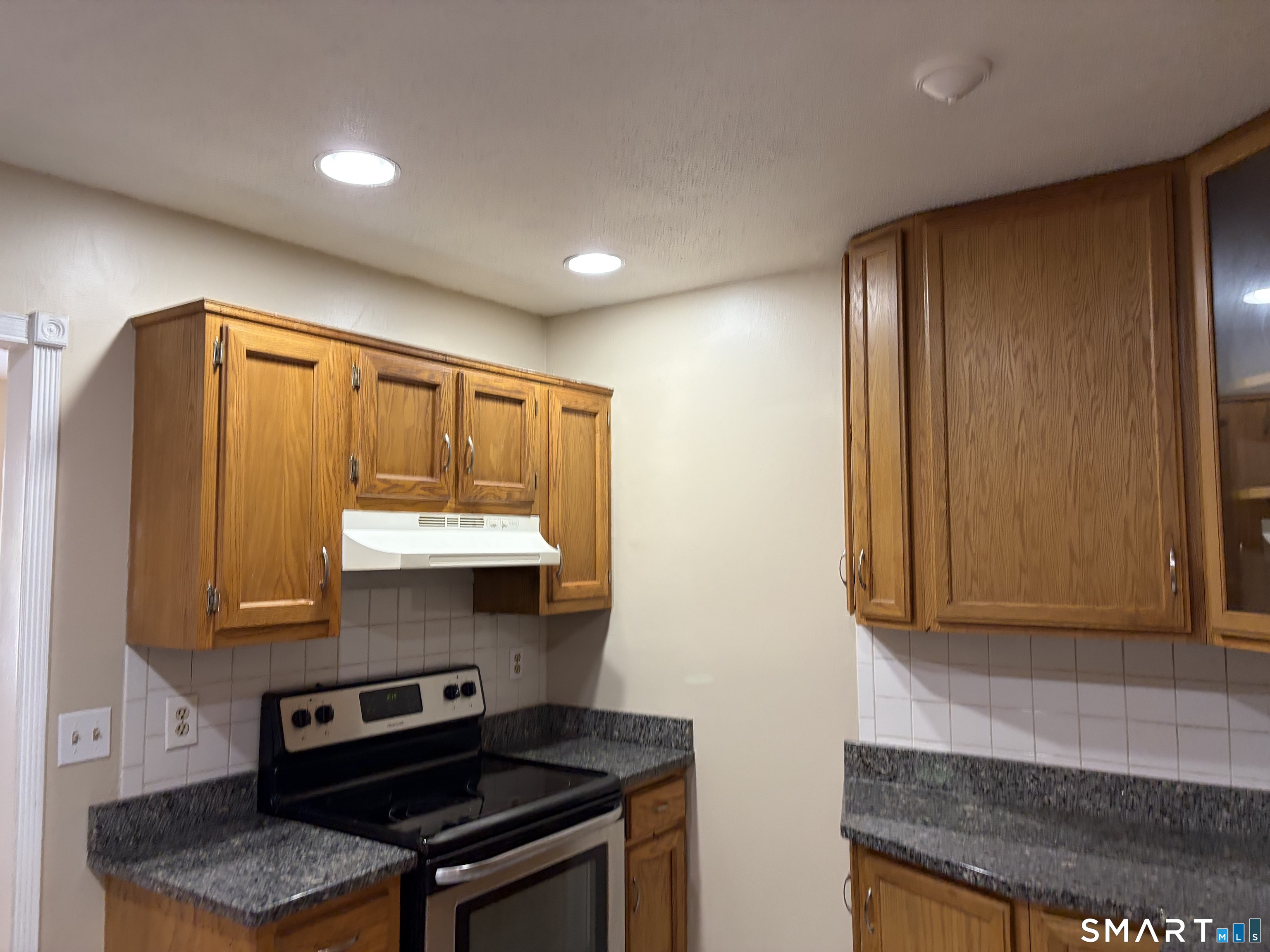 166 Old Brookfield Road, Unit 20B1 Danbury, CT 06811 - Photo 20 of 30 a kitchen with stainless steel appliances granite countertop a stove a sink and a microwave