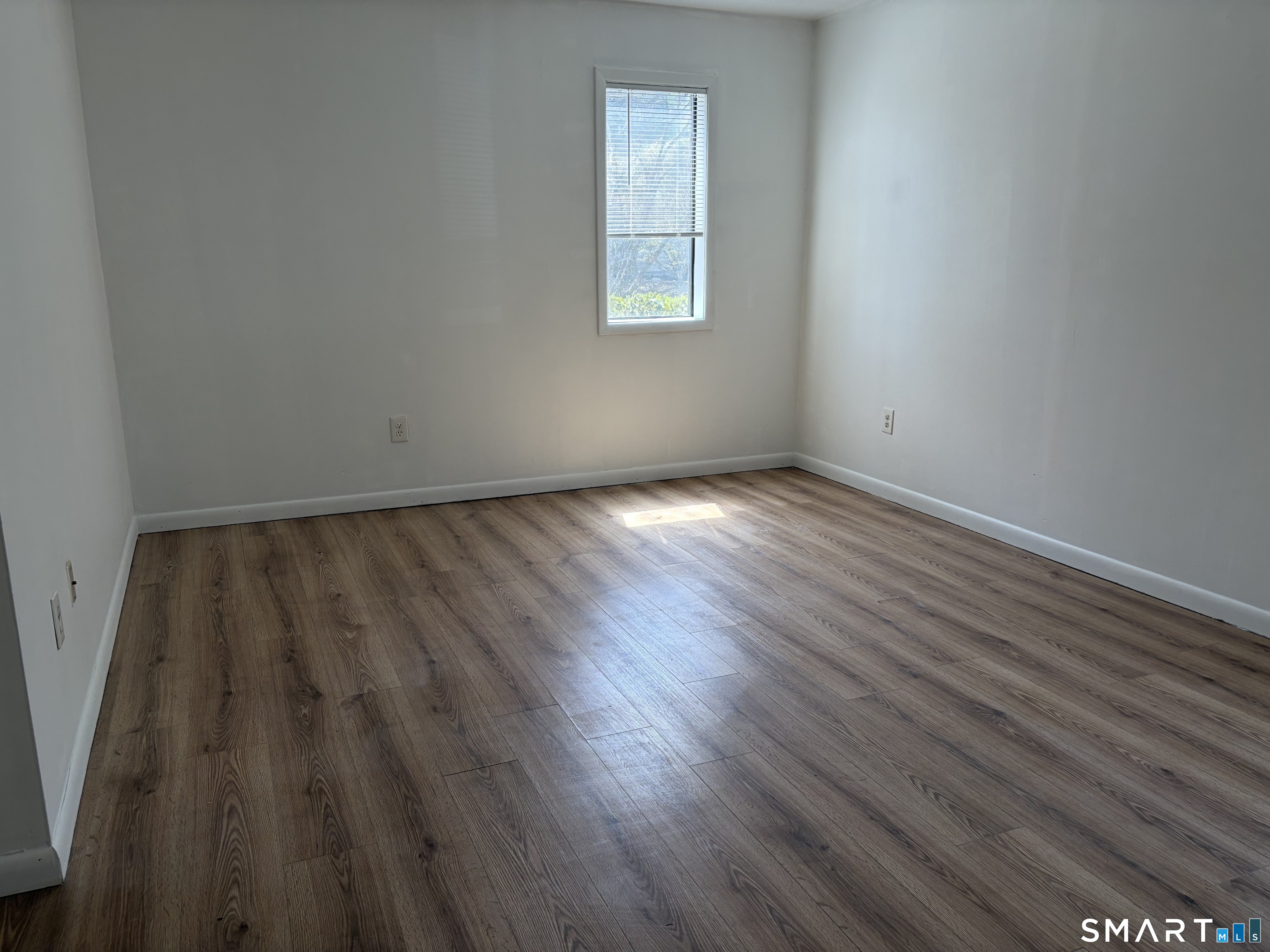 166 Old Brookfield Road, Unit 20B1 Danbury, CT 06811 - Photo 23 of 30 a view of an empty room with wooden floor and a window