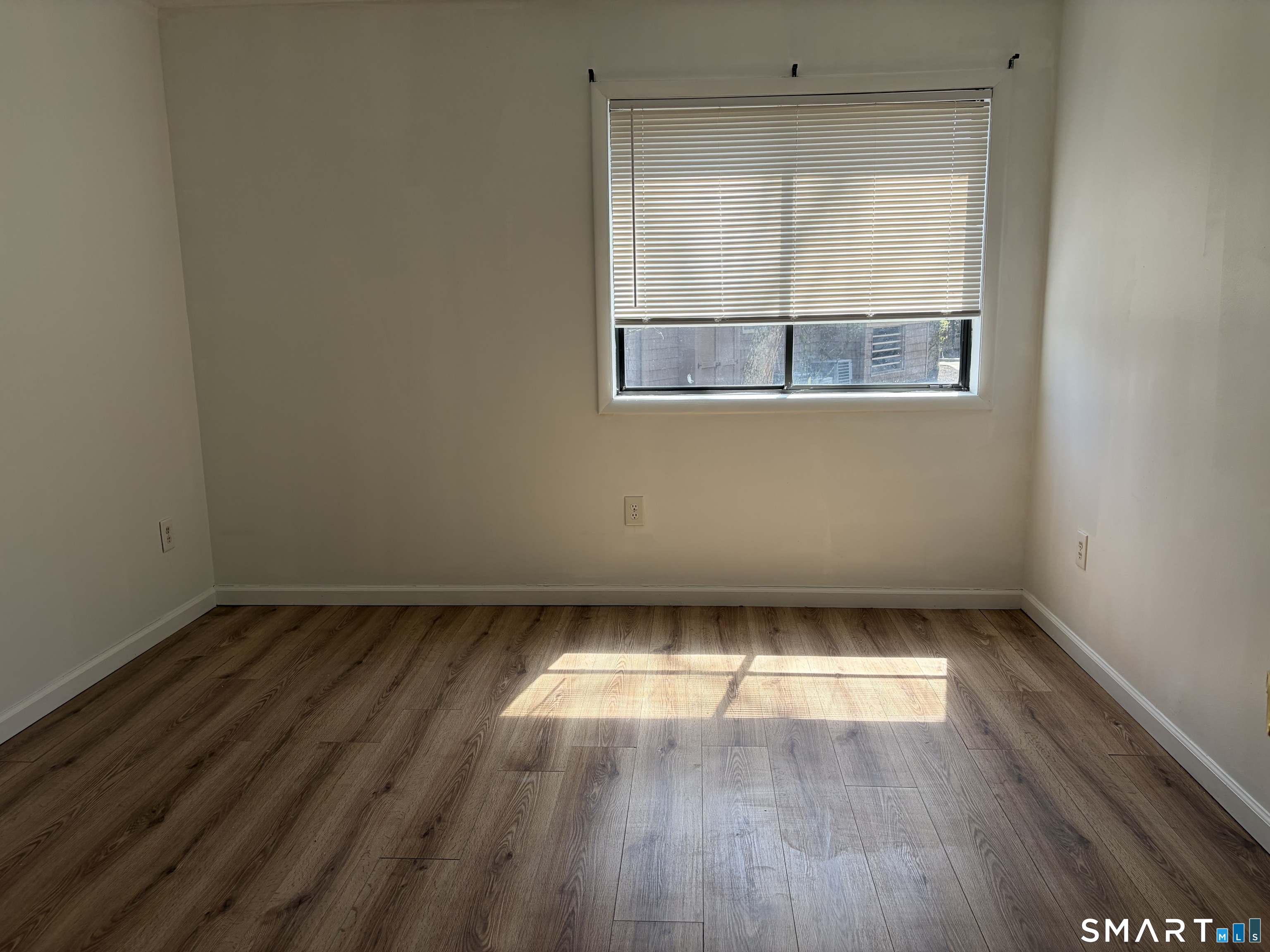 166 Old Brookfield Road, Unit 20B1 Danbury, CT 06811 - Photo 27 of 30 an empty room with wooden floor and windows