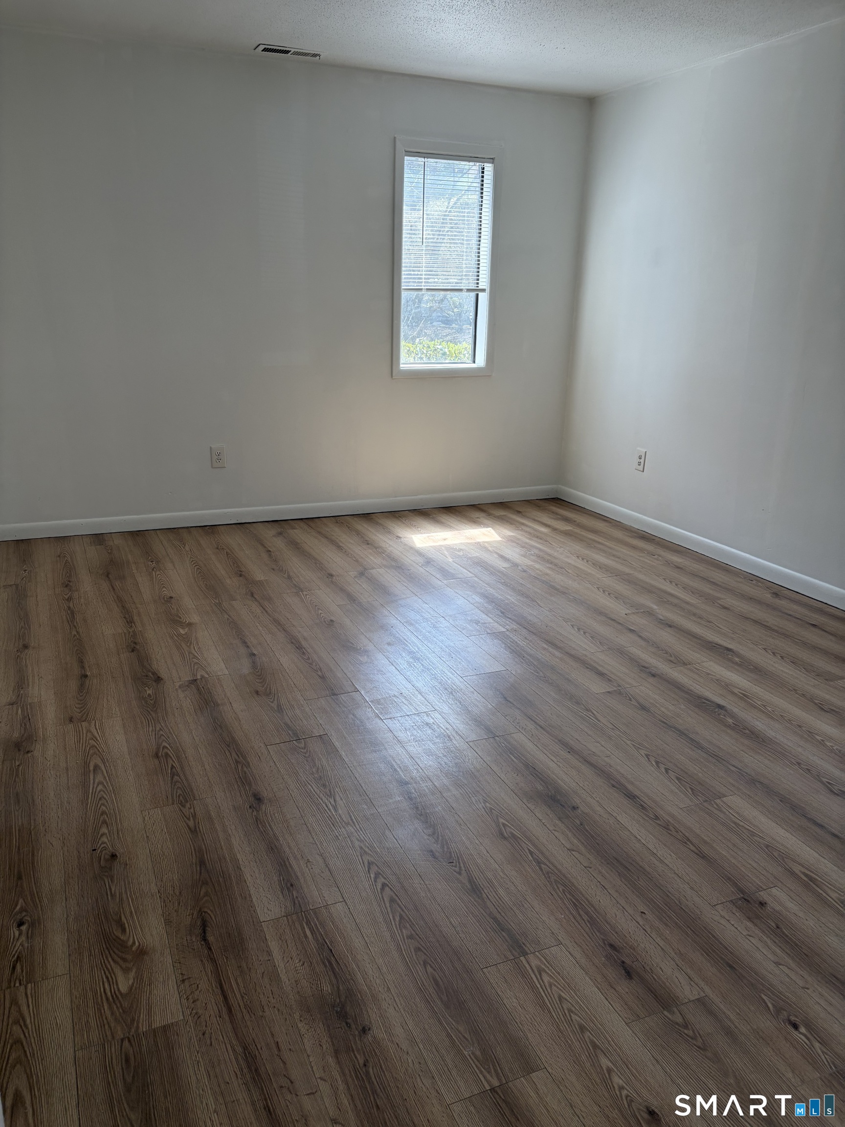166 Old Brookfield Road, Unit 20B1 Danbury, CT 06811 - Photo 28 of 30 an empty room with wooden floor and windows