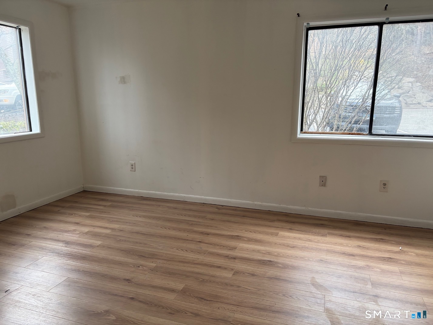 166 Old Brookfield Road, Unit 20B1 Danbury, CT 06811 - Photo 4 of 30 a view of an empty room with wooden floor and a window