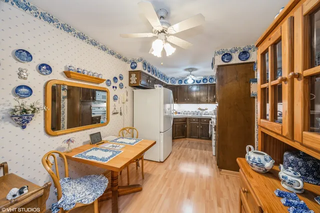 a kitchen with stainless steel appliances granite countertop a refrigerator a stove a sink dishwasher and a dining table with wooden floor