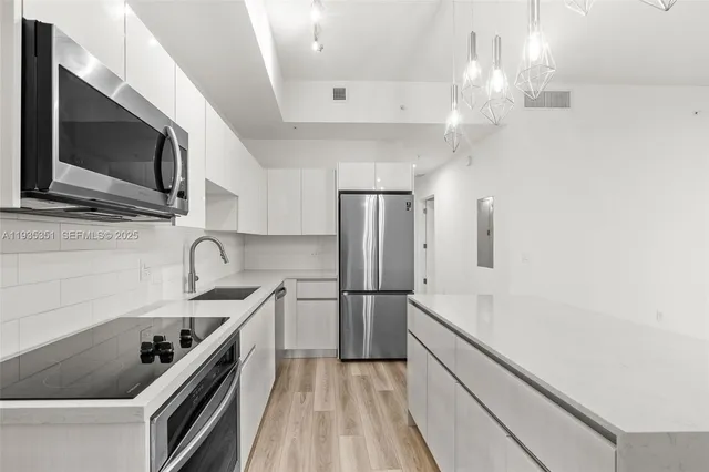 a kitchen with stainless steel appliances a sink stove and refrigerator