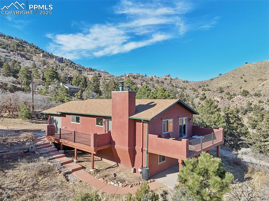 975 Crystal Park Road Manitou Springs, CO 80829 - Photo 32 of 38 aerial view of a house with a yard and balcony