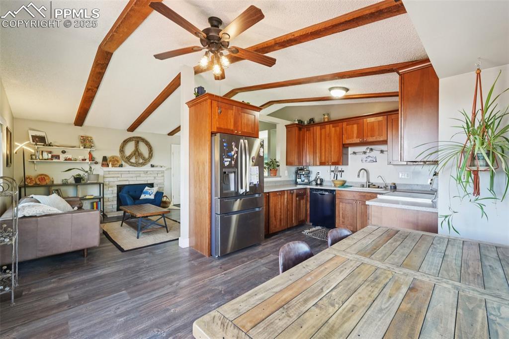 975 Crystal Park Road Manitou Springs, CO 80829 - Photo 7 of 38 a view of a living room and kitchen with furniture a fireplace wooden floor and chandelier